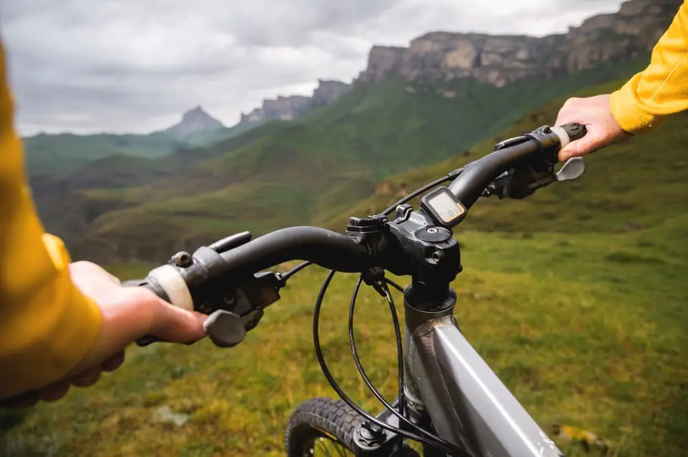 cyclist holding the handlebars of her mountain bike