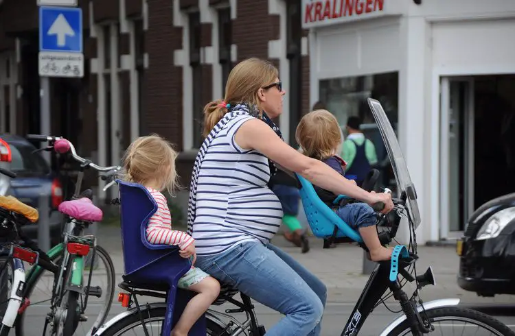 pregnant woman cycling with kids