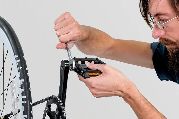 Man replacing pedal on his own bike